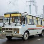 mini bus with unrecognizable driver and passengers on city road