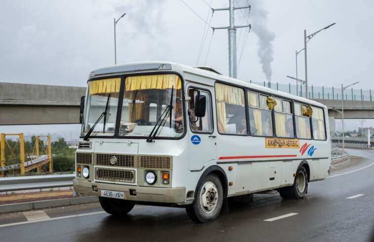 mini bus with unrecognizable driver and passengers on city road